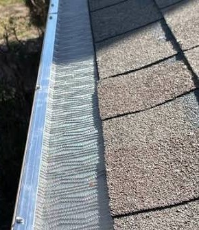 Cleared eavestrough with a fine mesh guard installed over the trough